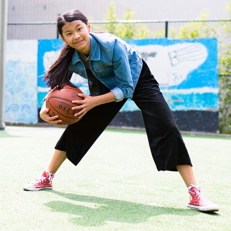 Student playing basketball outdoors