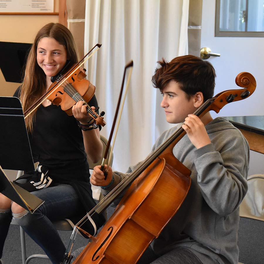 Studnets playing violin and cello in class