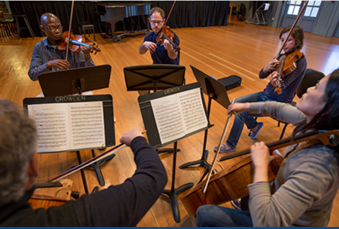 String quartet rehearsing in wooden music studio