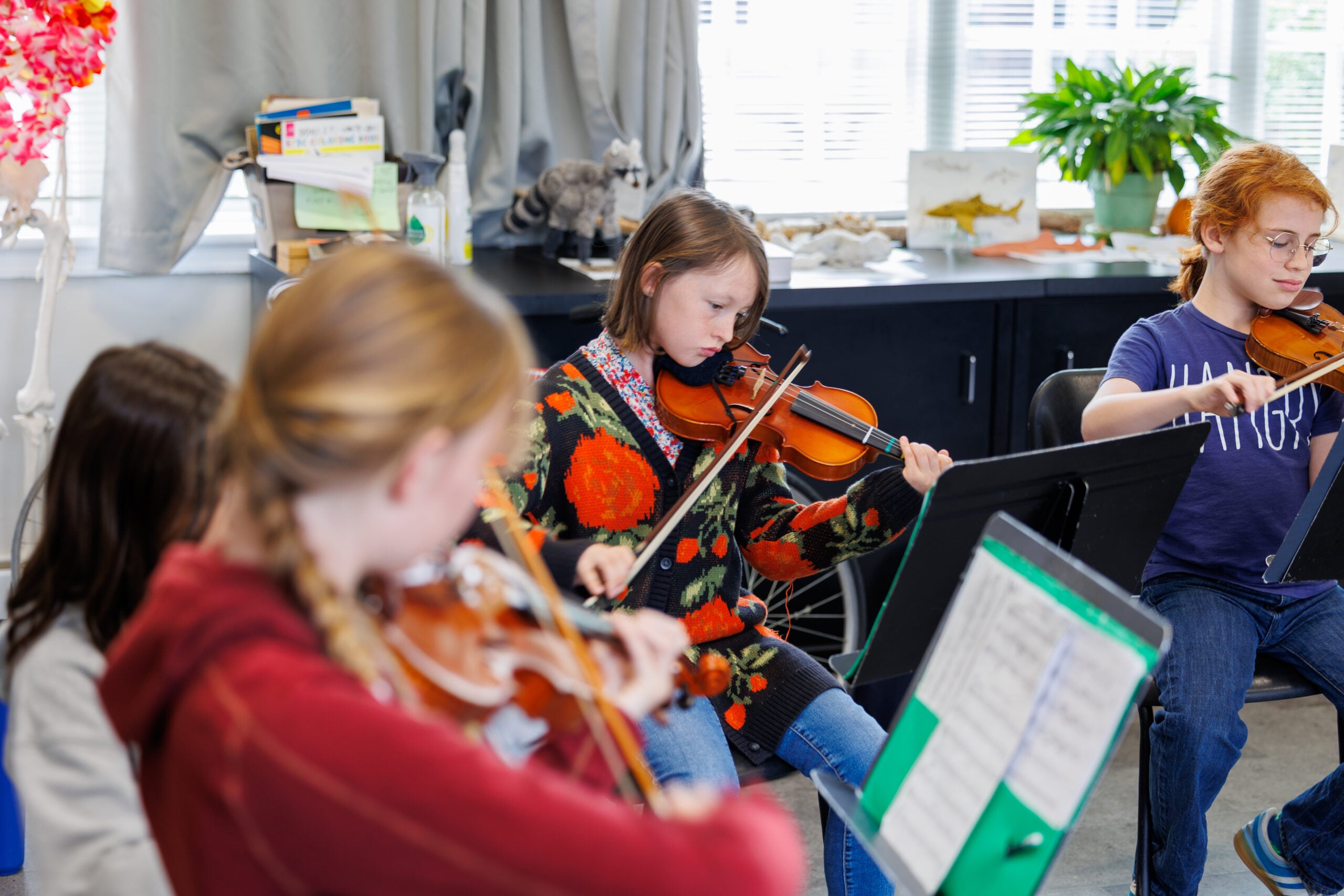 Children playing violins in classroom setting