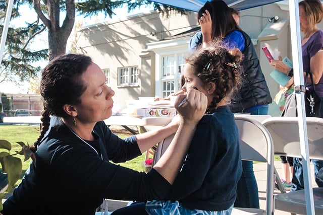 Face painting at outdoor event for children.