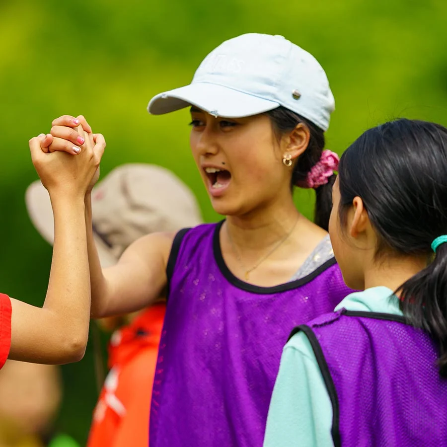 Youth sports team celebrating victory outdoors.