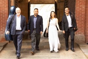 Four professionals walking together outside building