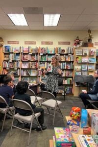 Author reading to children in bookstore event.