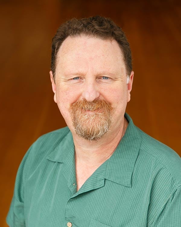 Man with beard in green shirt smiling