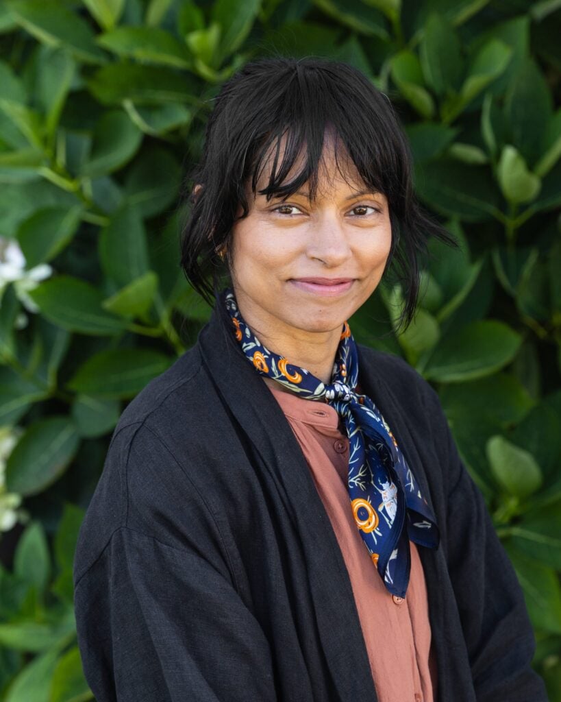 Person smiling with leafy background
