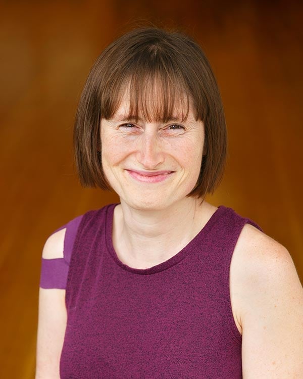 Woman smiling in purple sleeveless top