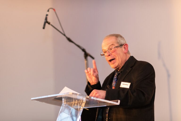 Man speaking at podium with microphone.