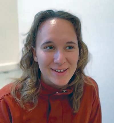 Smiling person in red shirt indoors