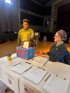 Person voting at polling station table