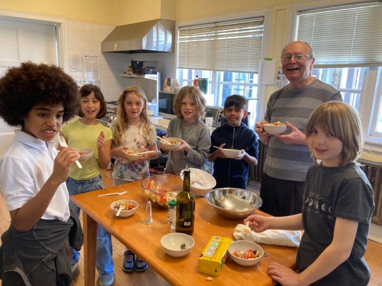 Children cooking with an adult in a kitchen.