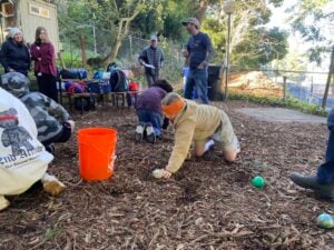Kids play outside, digging in the dirt.