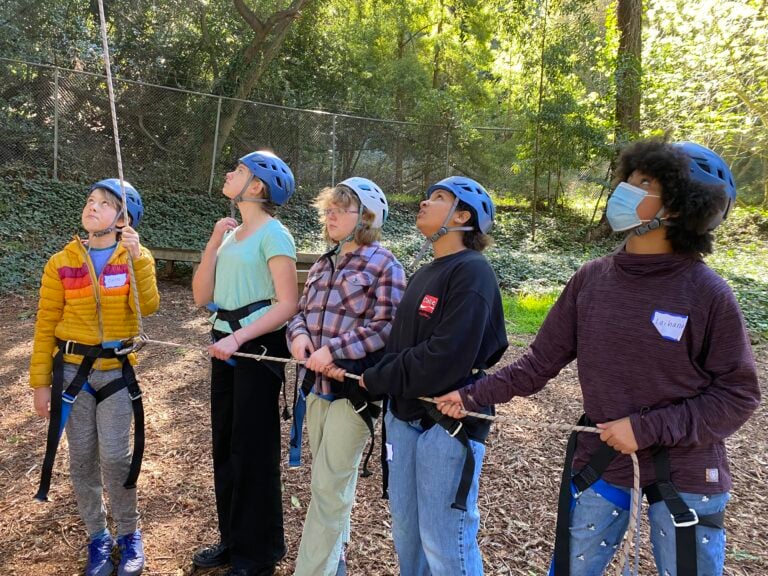 Group belaying in outdoor climbing adventure.