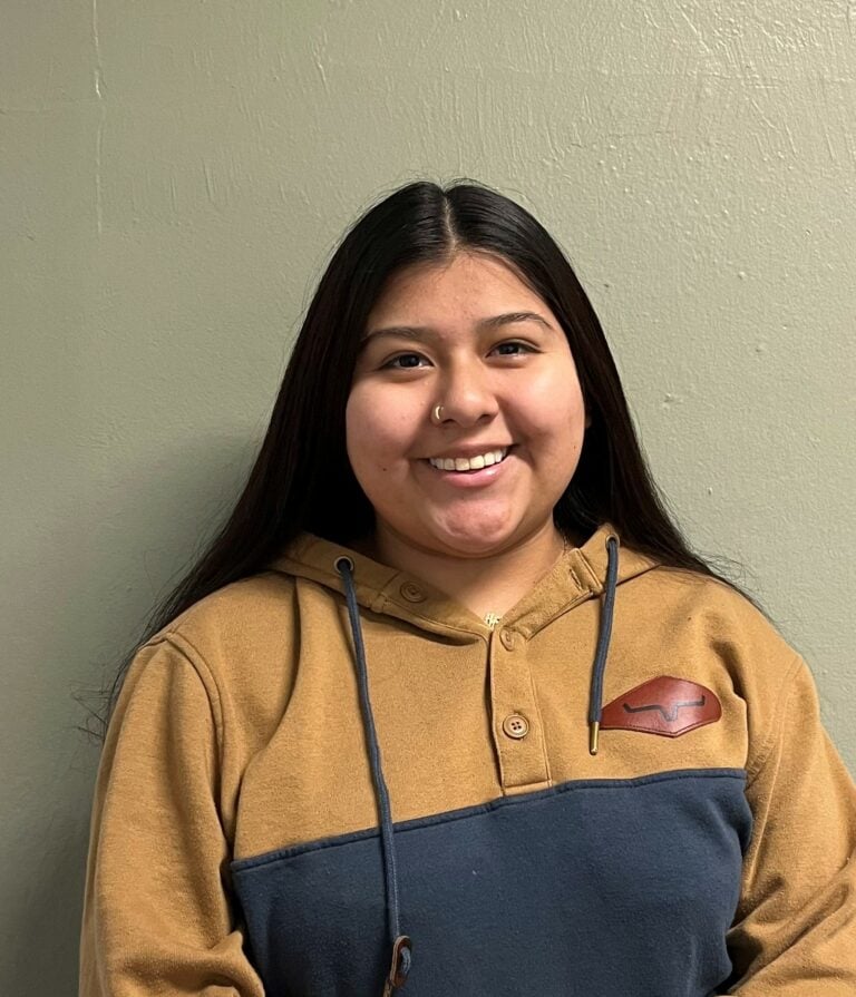 Person smiling in a two-tone hoodie