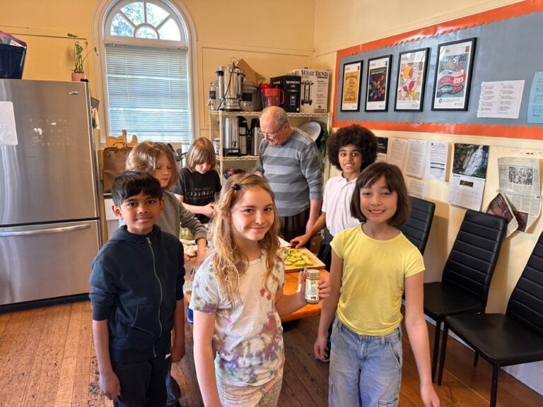 Group of children in a classroom kitchen setting.