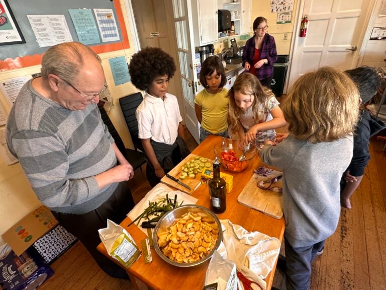 Children and man preparing ingredients in a kitchen.