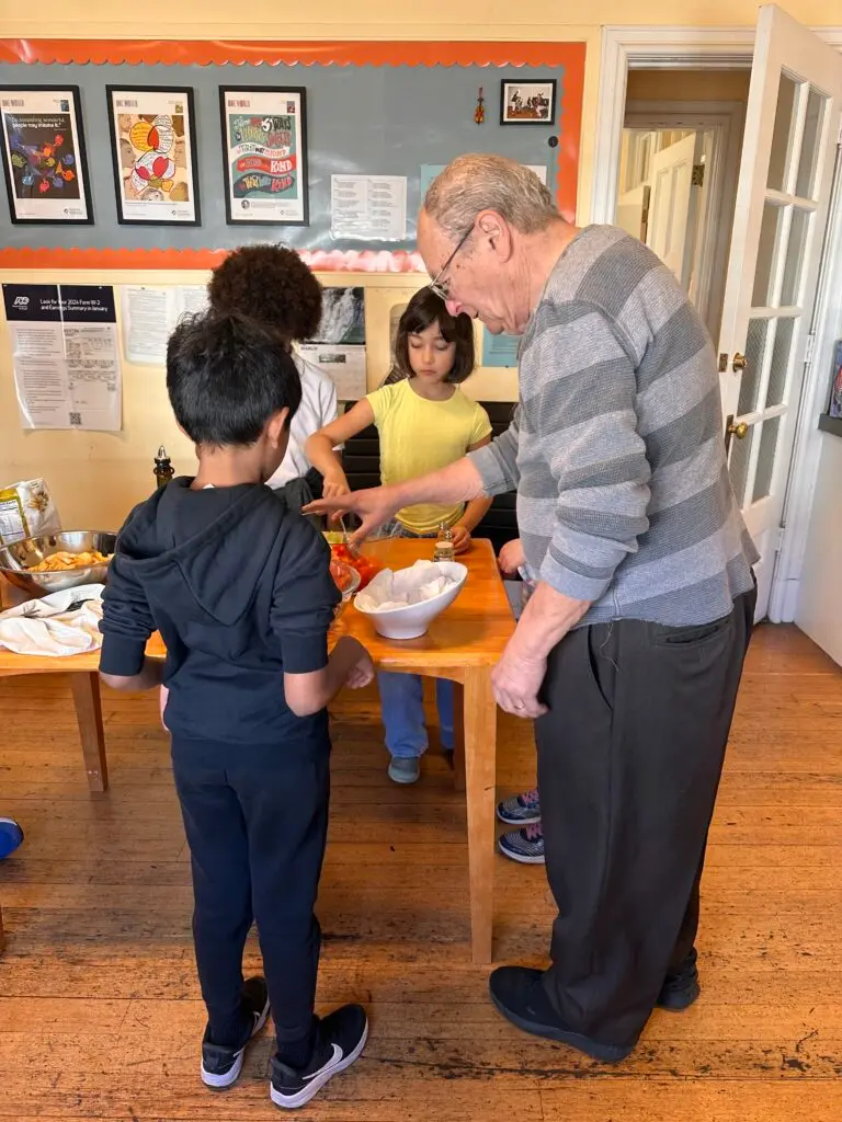 People serving food on a wooden table.