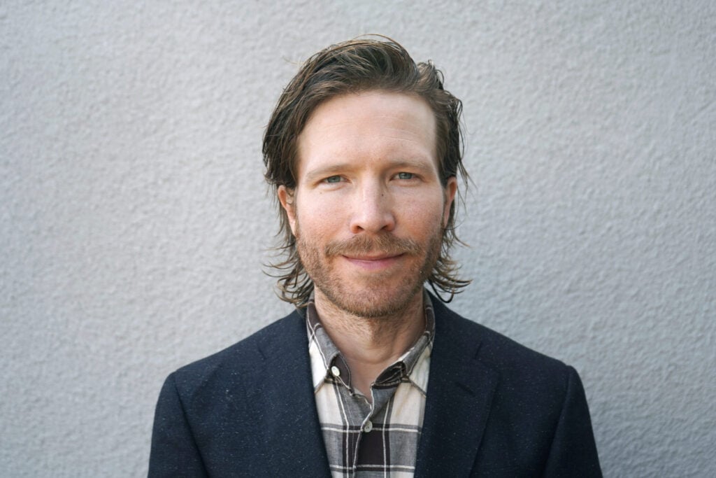 Smiling man in plaid shirt and jacket