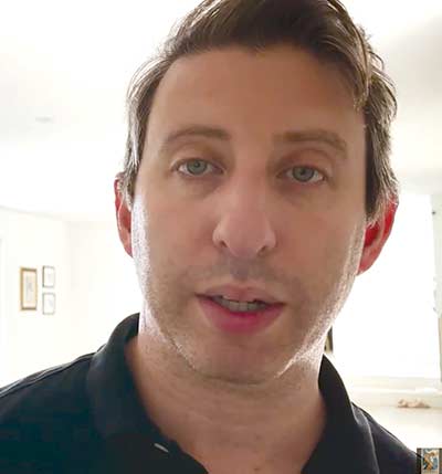 Person indoors facing camera, neutral expression, wearing black shirt.