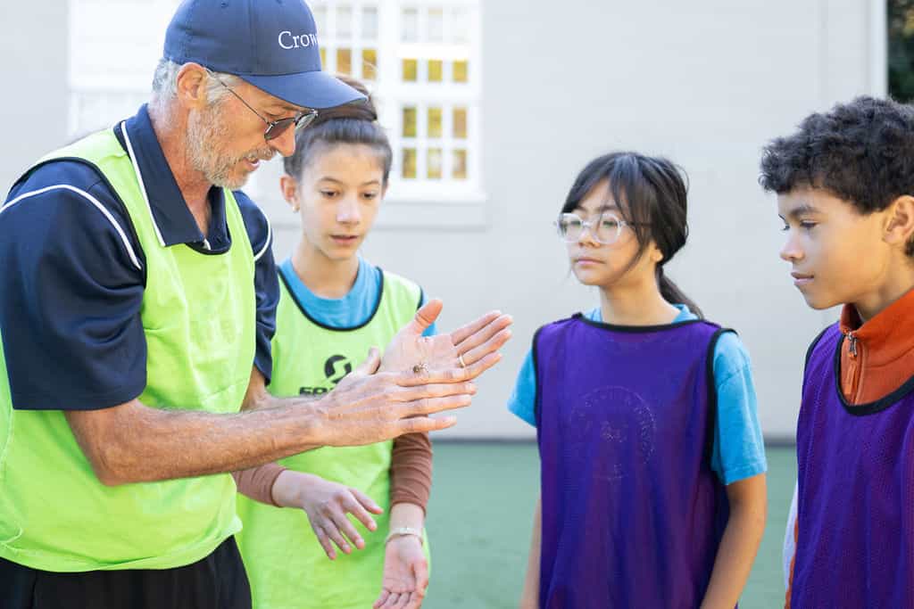 Coach explaining soccer strategy to young players.
