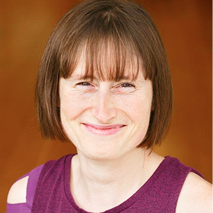 Smiling person with short, brown hair and bangs.