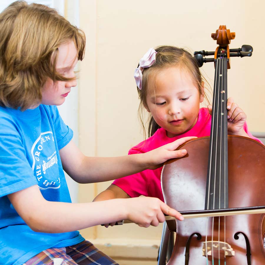 Children learning to play the cello together.