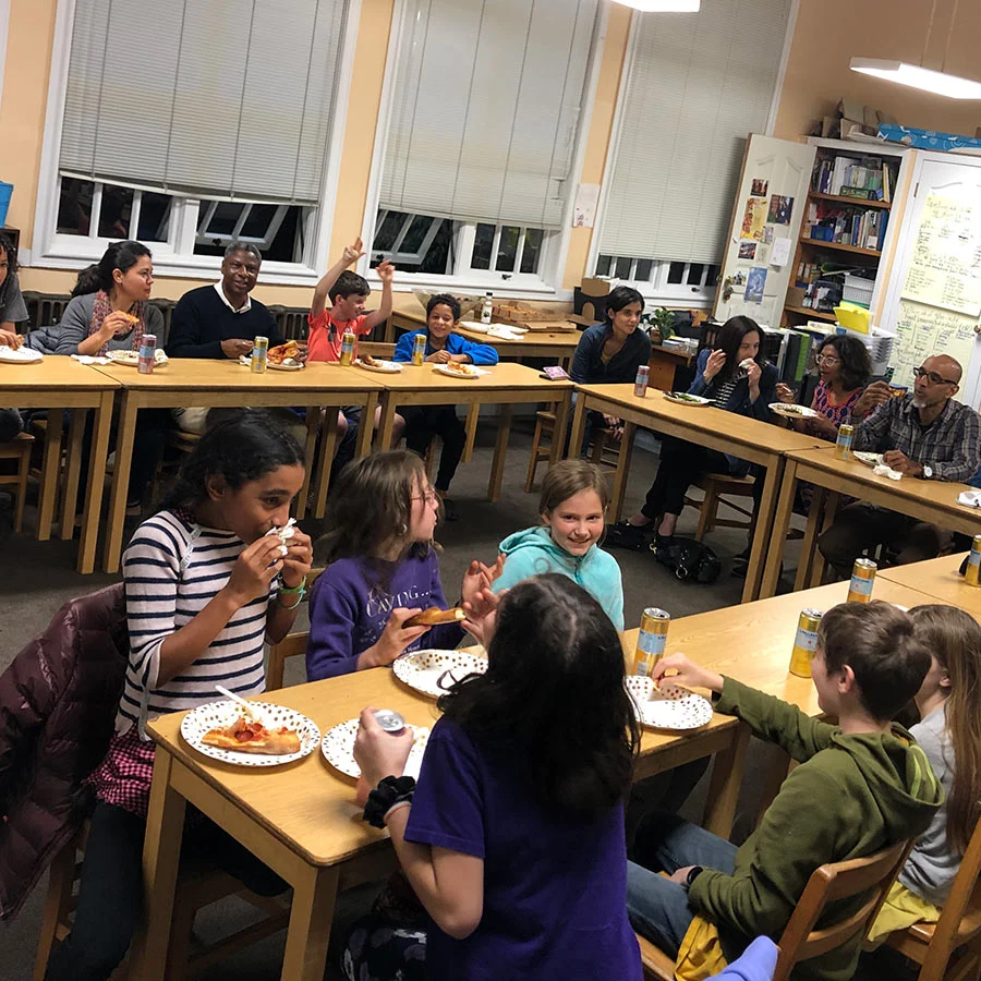 Students enjoying a pizza party in classroom.