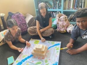 Kids playing board game on the floor.