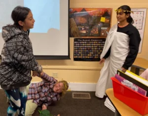 Students in classroom performing a historical skit.