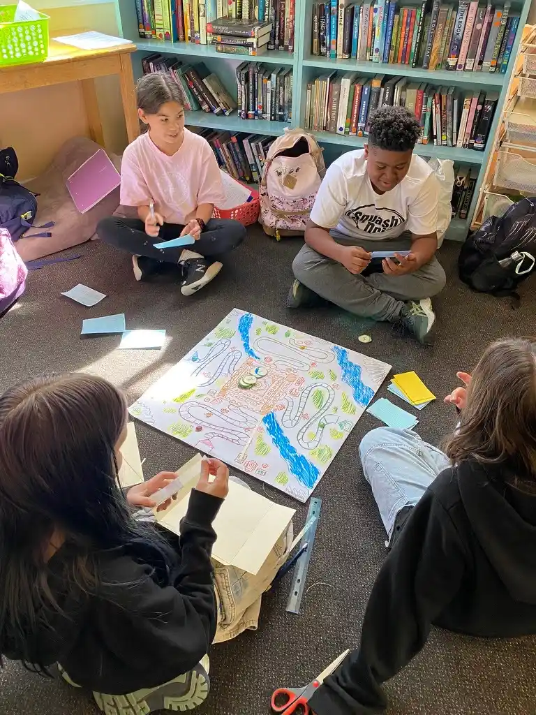 Students engaged in board game activity in library.