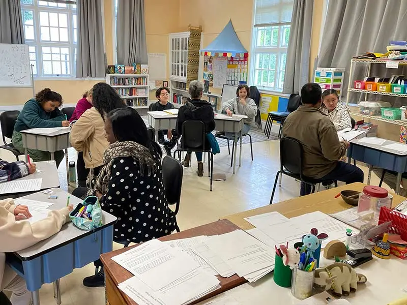 Adult learners in classroom environment working together.