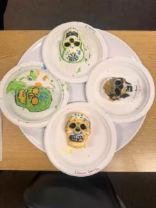 Colorful skull cookies on paper plates.