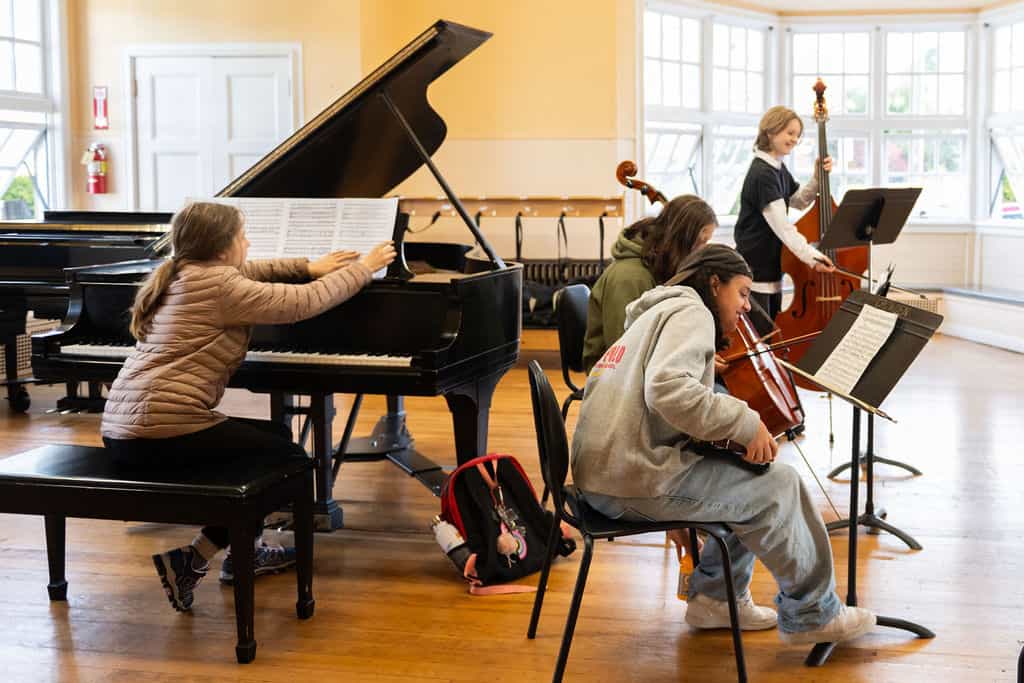 Students rehearsing music in a classroom setting.