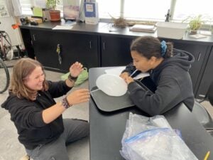 Students conducting an experiment with tray and balloon.