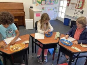Children learning money counting in classroom activity.
