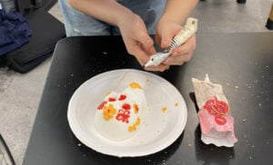 Decorating sugar skull with colorful icing designs.