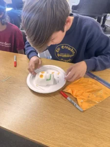 Child decorating sugar skull in classroom activity