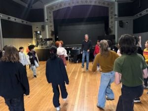 Group dance rehearsal in a theater studio.