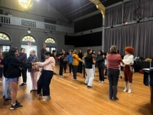 Group of students practicing theater in a gymnasium.