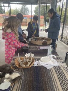 Children exploring basketry crafts outdoors.