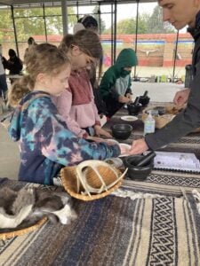 Children exploring educational outdoor activity exhibit.
