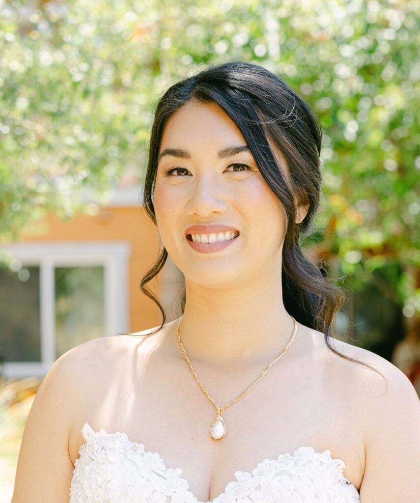 Smiling bride outdoors in sunlight