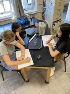 Three students studying together at school desk