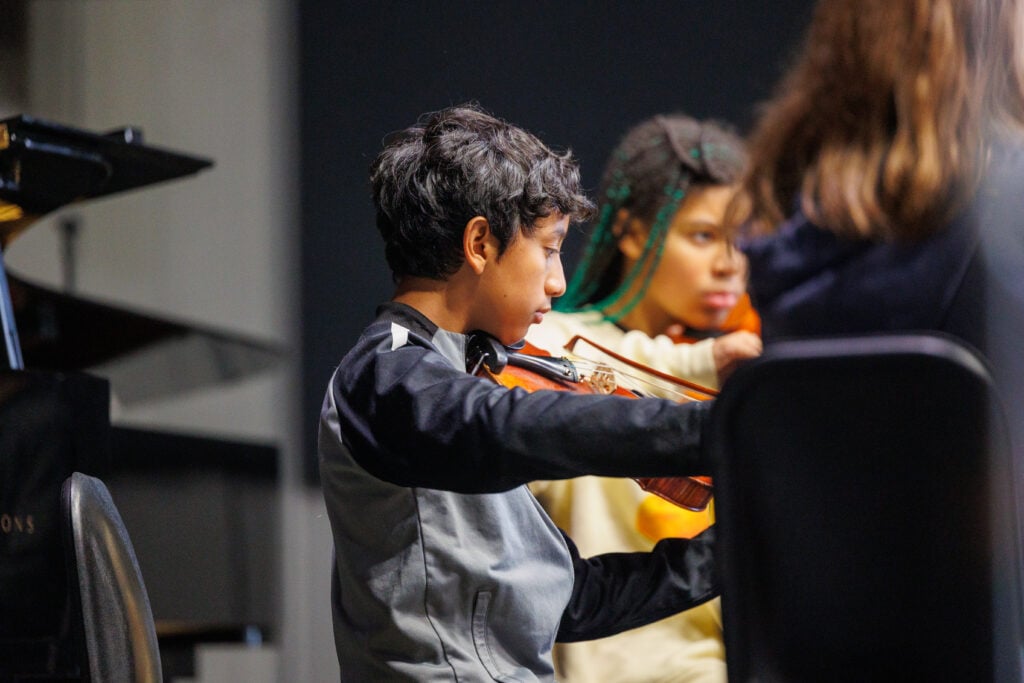 Child playing violin in music class
