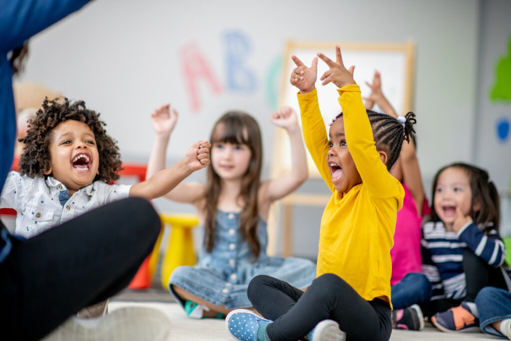 Children joyfully playing and cheering in classroom.