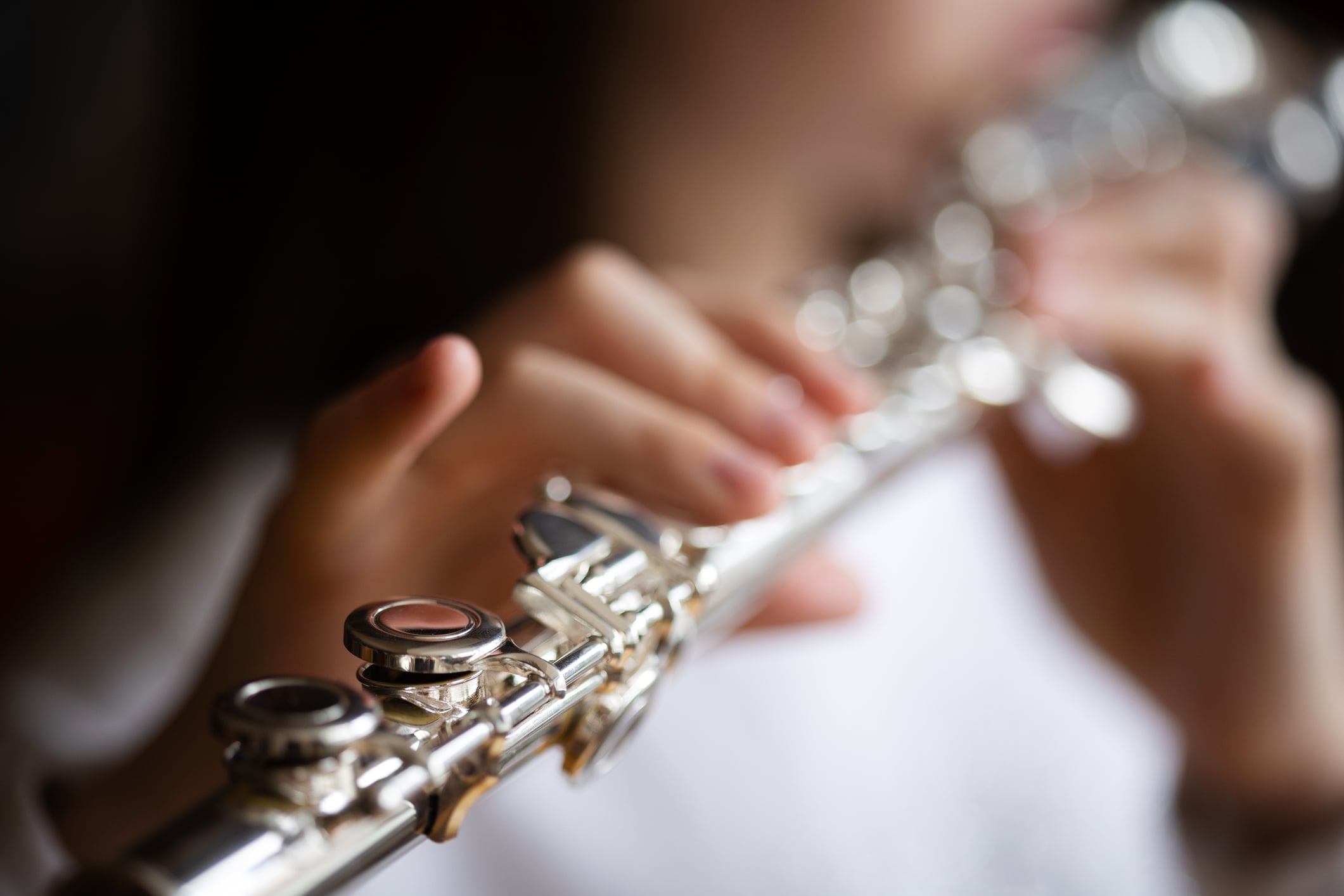Playing a silver flute close-up