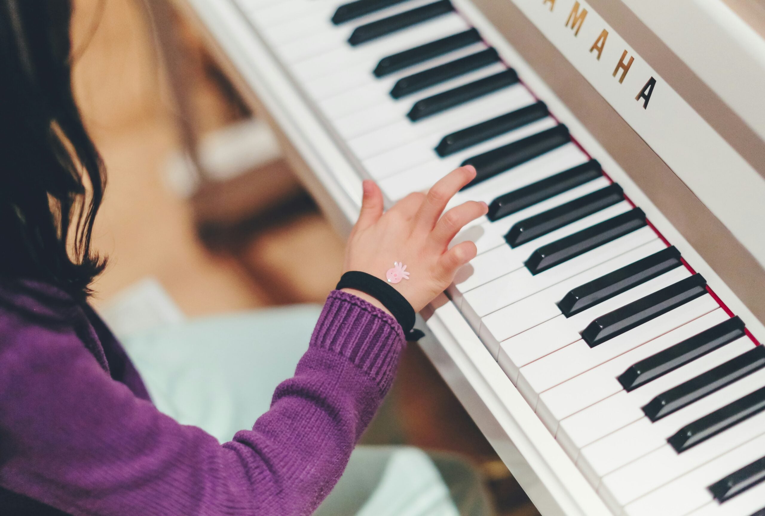 Child playing keys on Yamaha piano keyboard