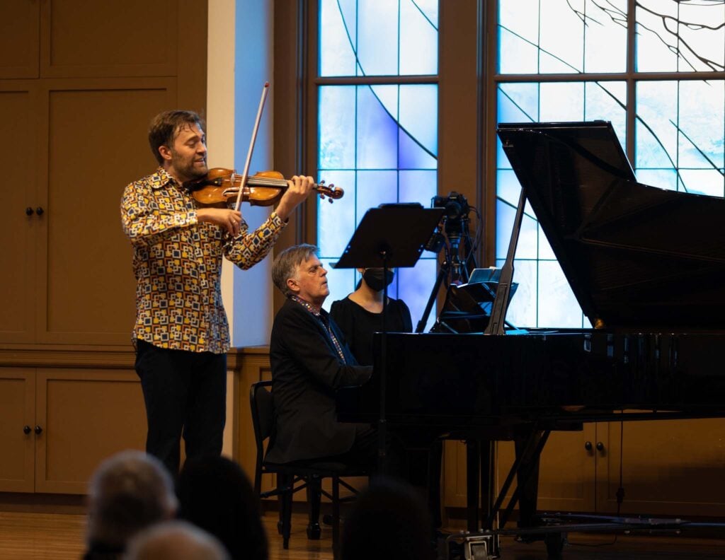 Owen Dalby performs beside pianist at grand piano